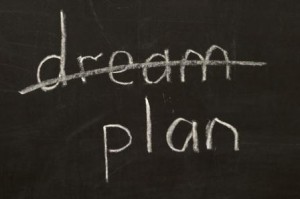 Crossed dream word and plan word chalk drawing over blackboard